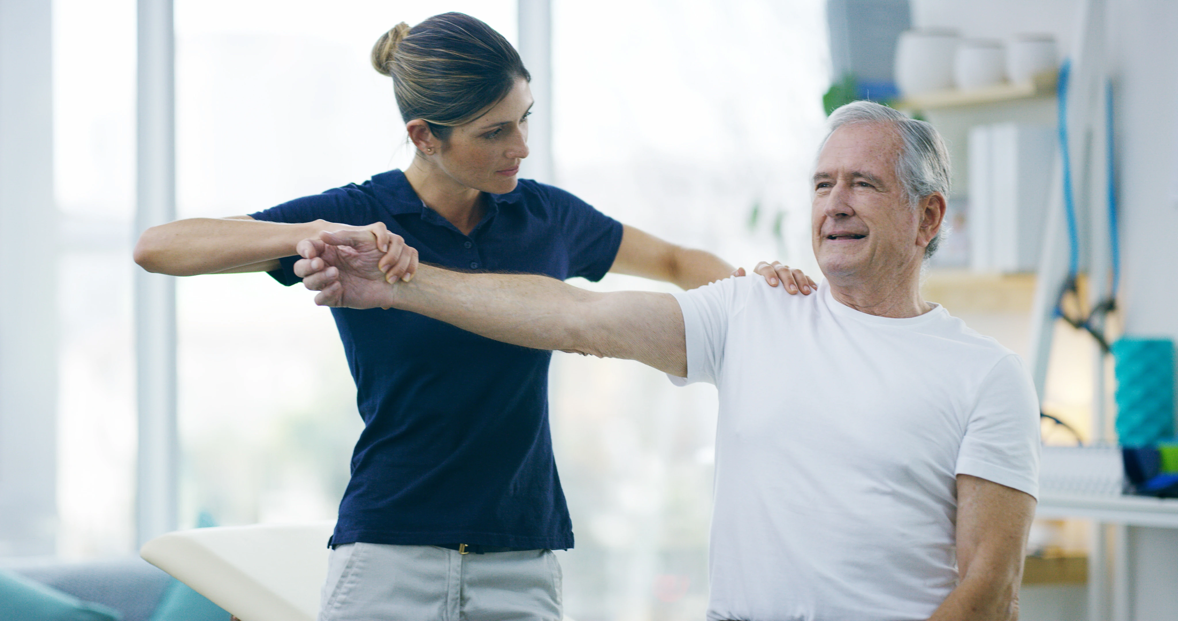 A physical therapist guiding a patient through a shoulder stretch