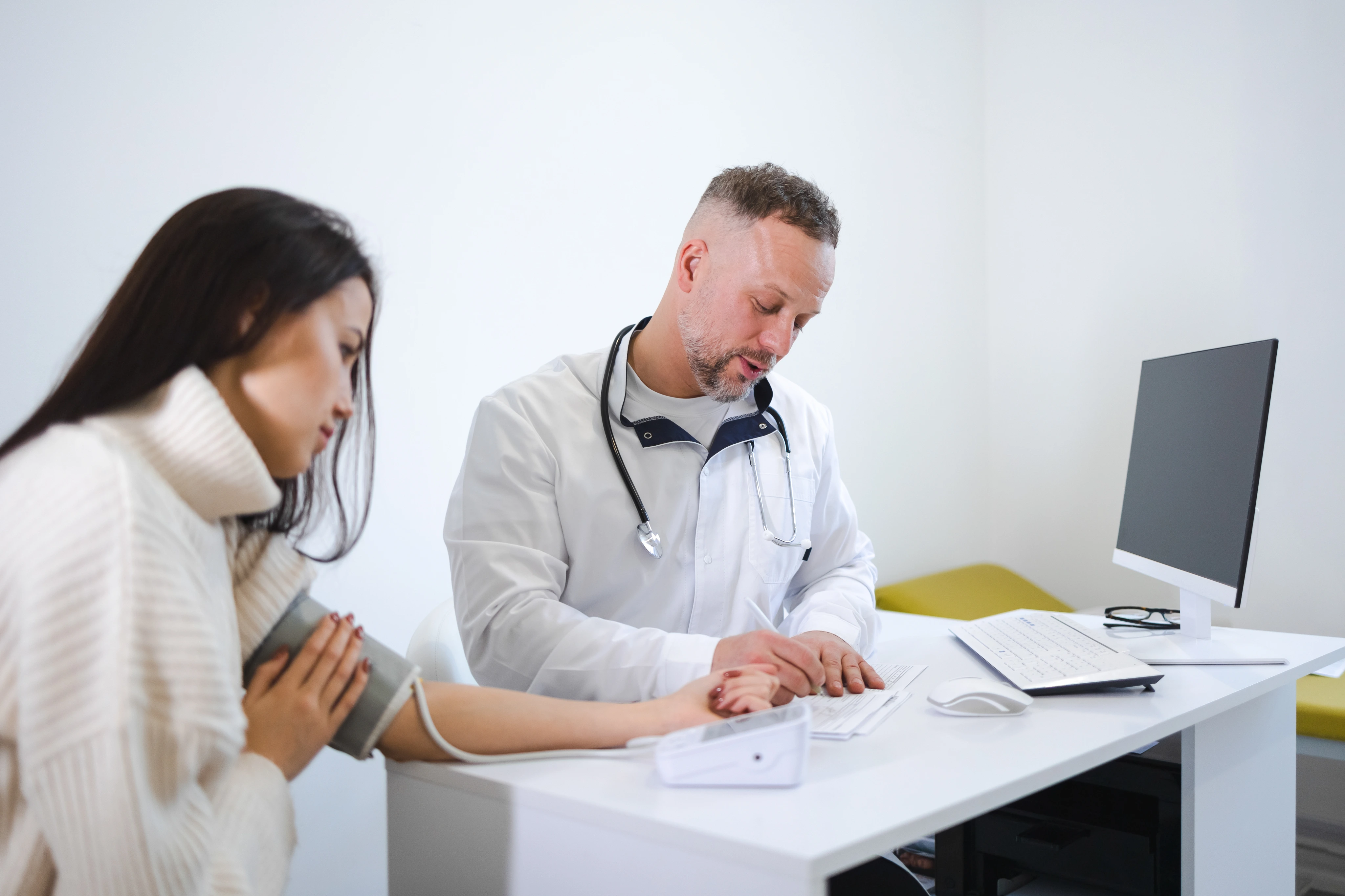 A doctor taking a patient&rsquo;s blood pressure