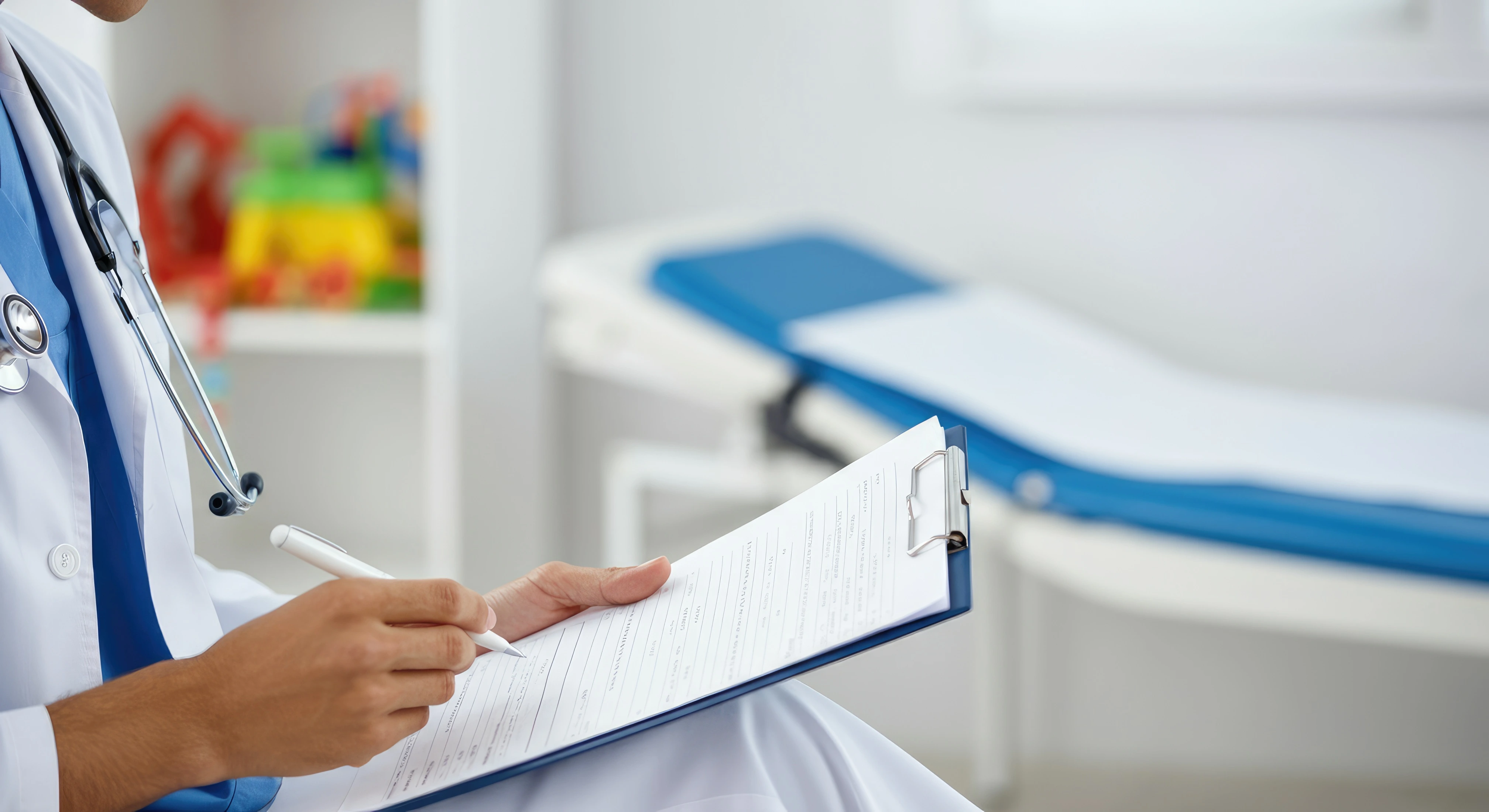A clinician writing on a chart in an exam room